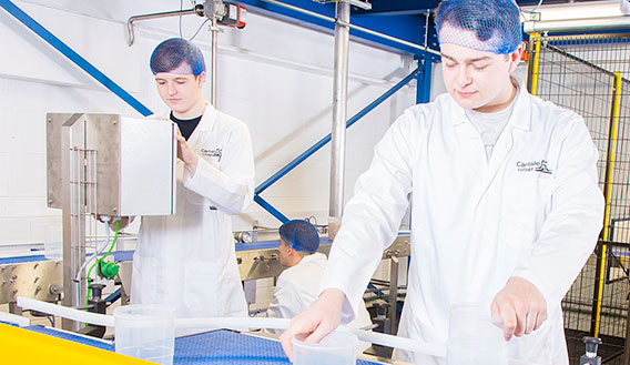 Photo of two students working on a simulated production line at Carlisle College Advanced Manufacturing Centre