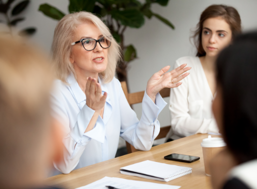 Photo of a woman talking in a meeting with other workers