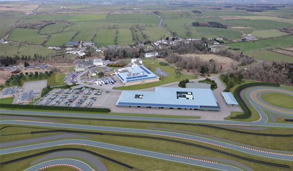 Aerial photograph of race track and surrounding buildings, surrounded by countryside