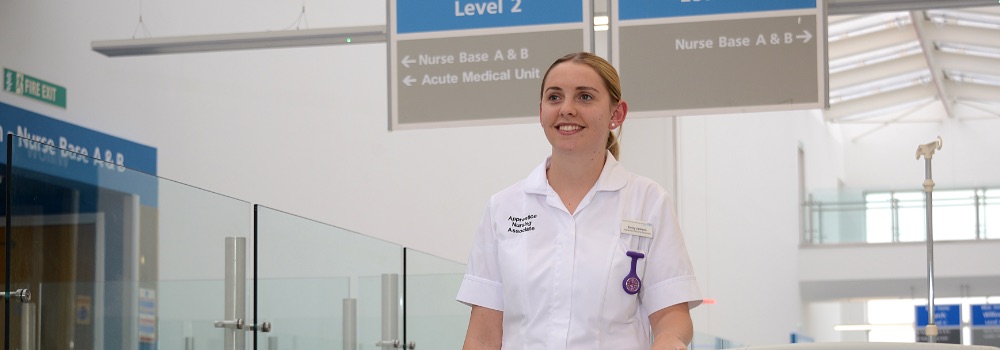 Photo of a smiling female nurse walking on ward